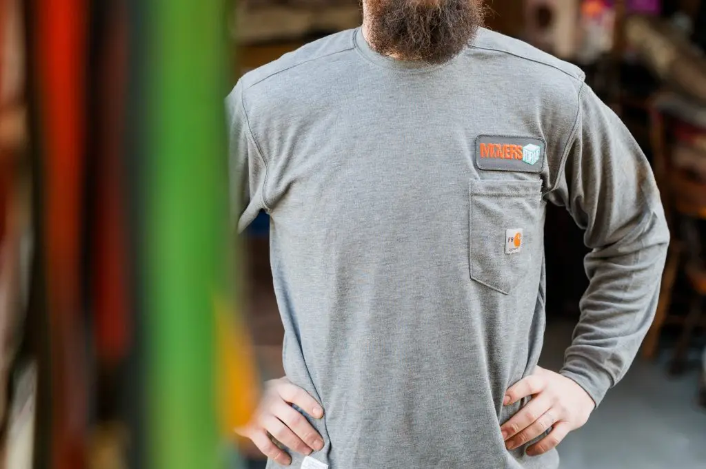 Movers using shrink wrap, and moving blankets to protect a dresser